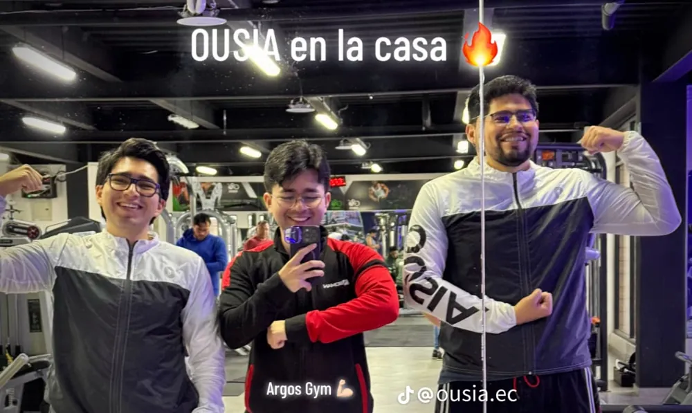 Tres hombres con chompas OUSIA en un gimnasio